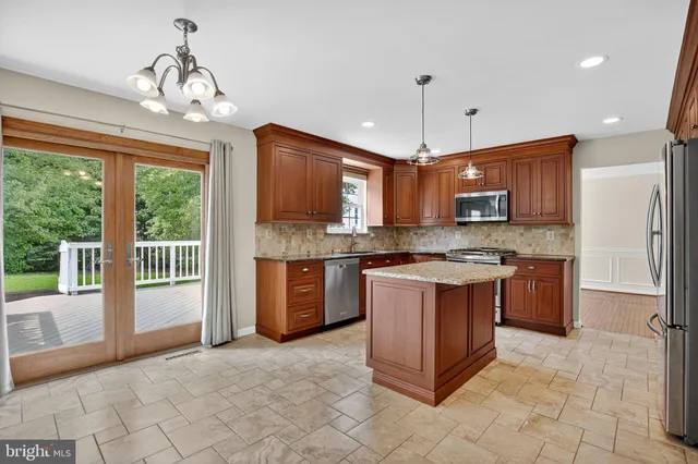 a large kitchen with stainless steel appliances granite countertop a stove granite counter tops and a view of living room