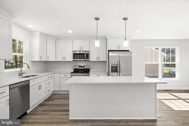 a large kitchen with stainless steel appliances granite countertop a stove a sink and a refrigerator