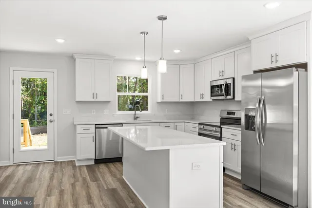 a kitchen with white cabinets stainless steel appliances and window
