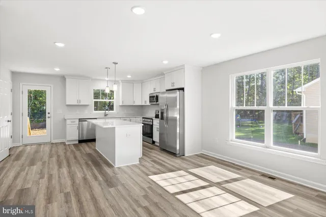 a kitchen with a refrigerator and a stove top oven
