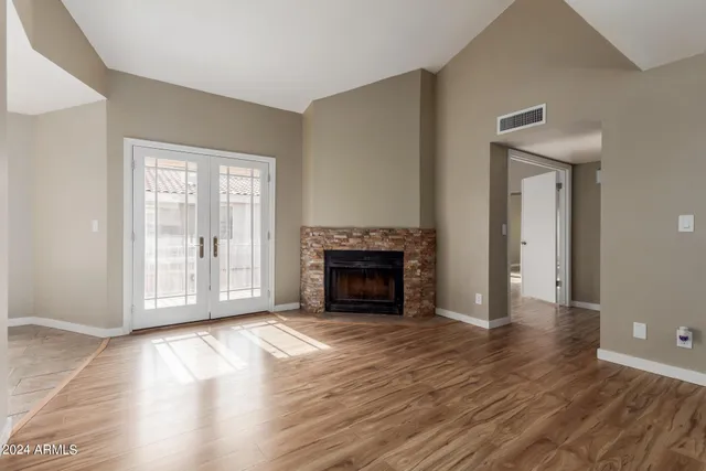 a view of empty room with wooden floor and fireplace