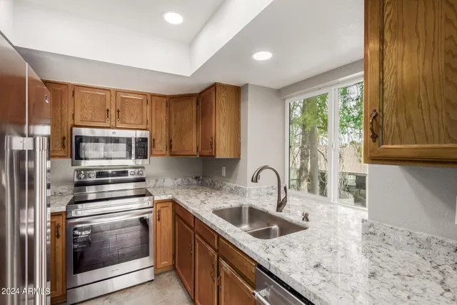 a kitchen with granite countertop a sink stove and cabinets