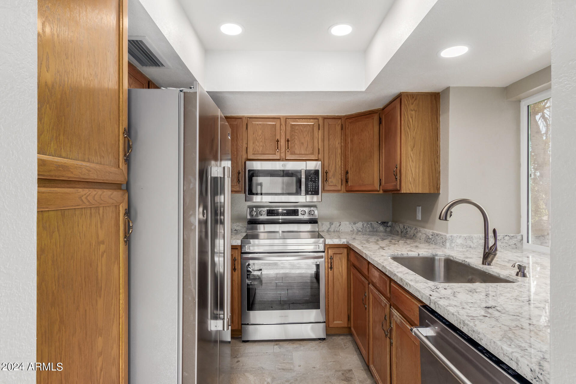 2834 South Ext Road, Unit 2058 Mesa, AZ 85210 - Photo 16 of 33 a kitchen with stainless steel appliances granite countertop a refrigerator and a sink