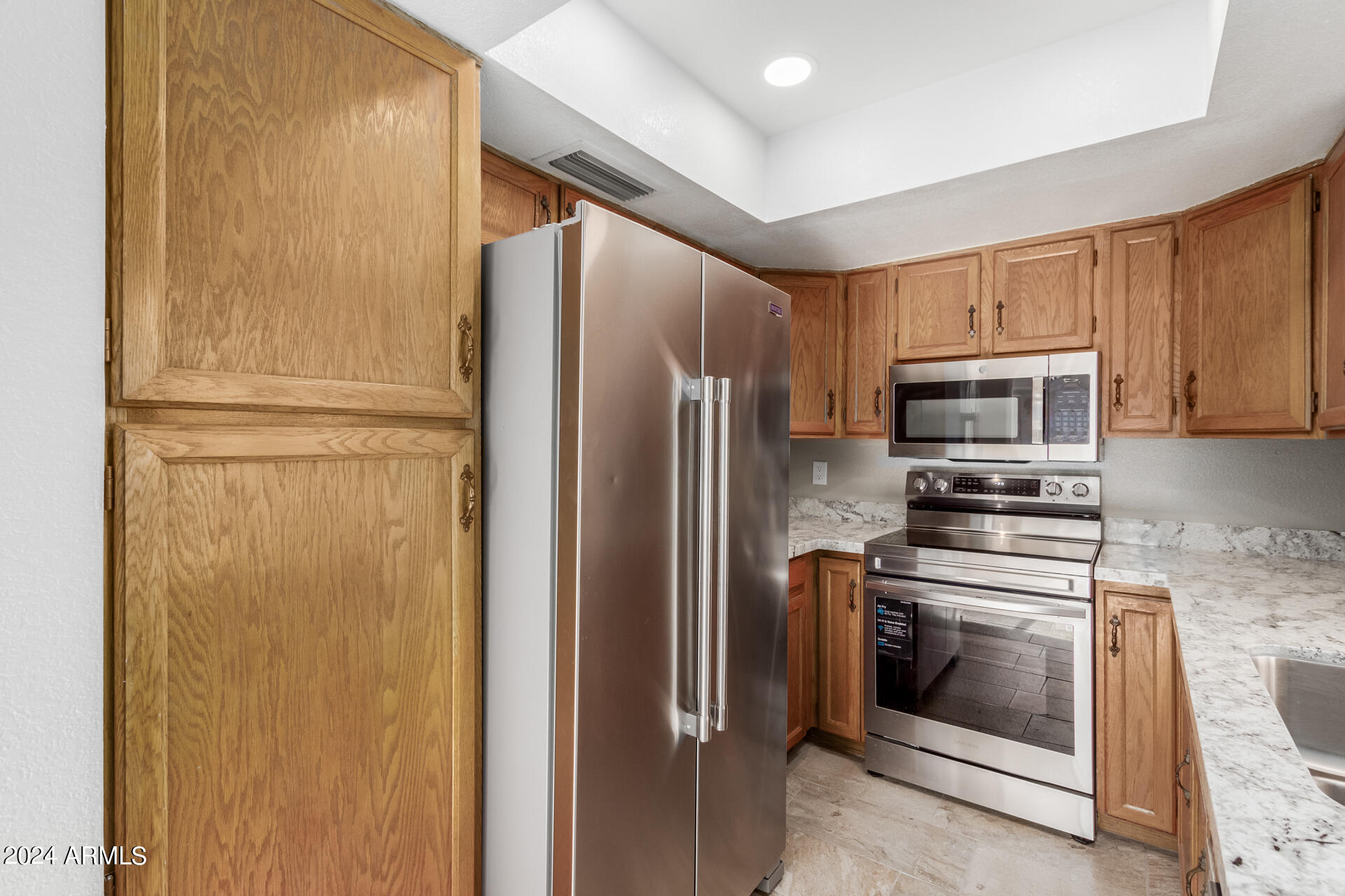 2834 South Ext Road, Unit 2058 Mesa, AZ 85210 - Photo 17 of 33 a kitchen with stainless steel appliances a refrigerator stove and microwave
