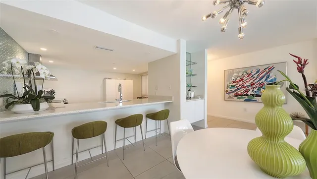 a large white kitchen with a sink and dishwasher a stove top oven with wooden floor