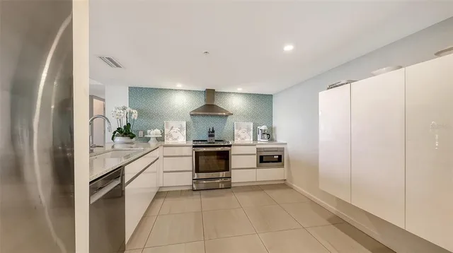 a kitchen with stainless steel appliances granite countertop a refrigerator and a sink