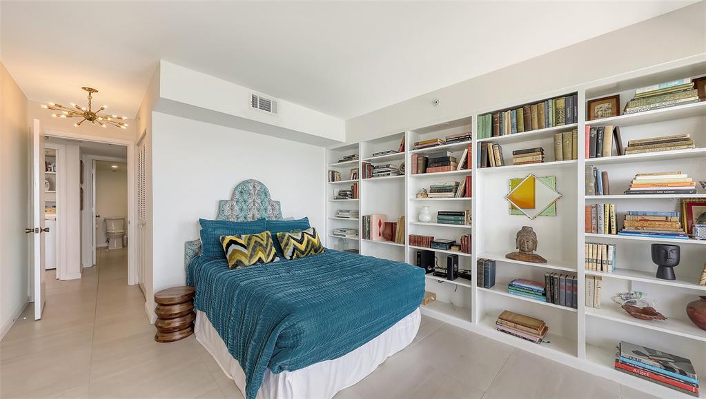 11 Sunset Drive, Unit 501 Sarasota, FL 34236 - Photo 31 of 63 a bedroom with a bed and a book shelf