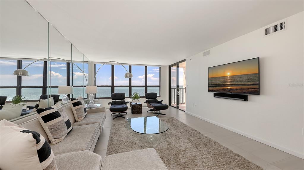 11 Sunset Drive, Unit 501 Sarasota, FL 34236 - Photo 7 of 63 a living room with furniture a flat screen tv and floor to ceiling window