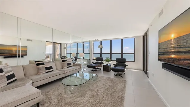a living room with furniture a large window and gym equipment
