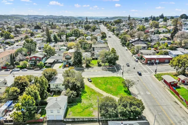an aerial view of residential houses with outdoor space and trees