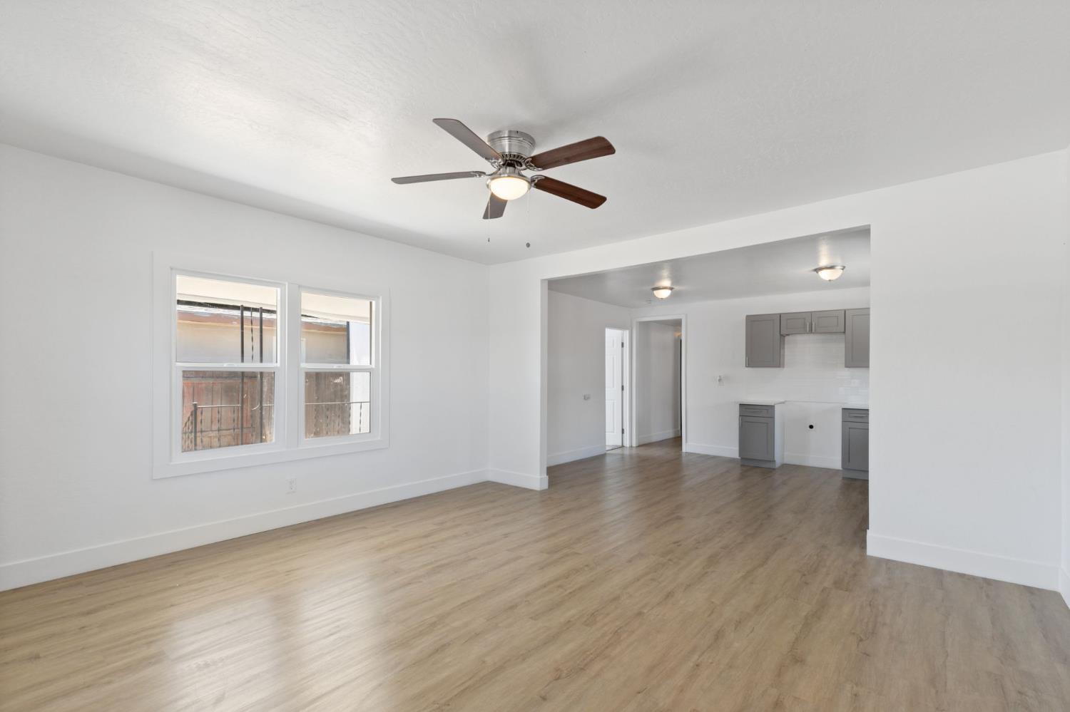 575 South 8th Street Kerman, CA 93630 - Photo 16 of 21 a view of an empty room with a window and wooden floor