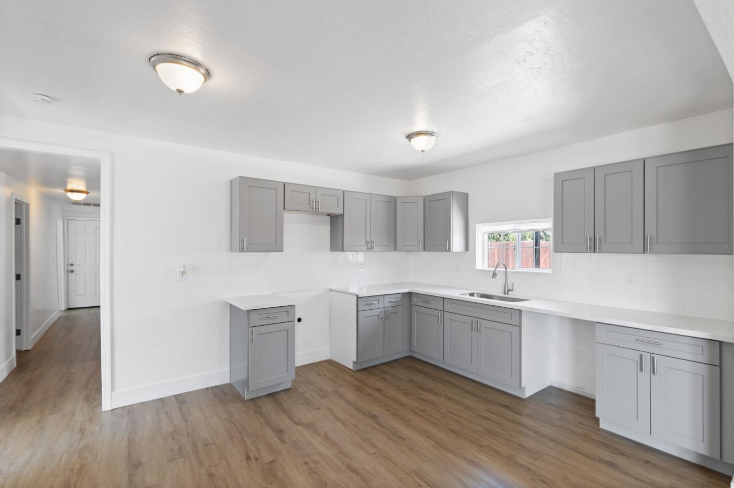 575 South 8th Street Kerman, CA 93630 - Photo 17 of 21 a kitchen with white cabinets and sink