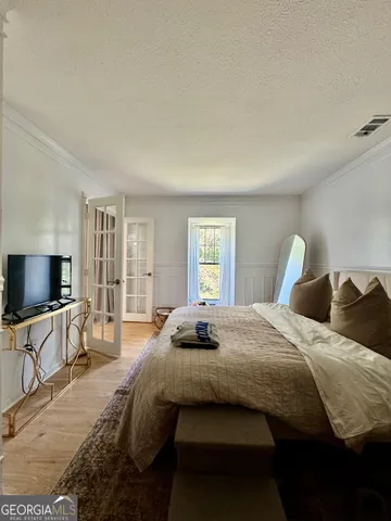 a bedroom with bed tv and window