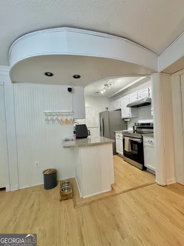 a kitchen with stainless steel appliances granite countertop a refrigerator and a stove top oven