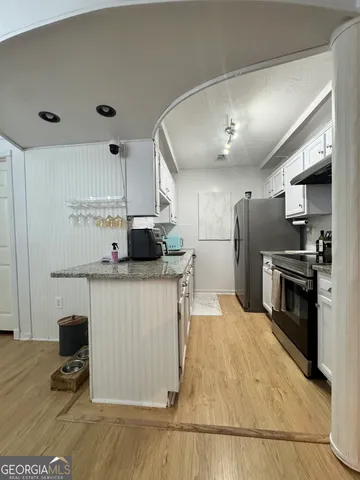 a kitchen with stainless steel appliances a stove refrigerator and a sink