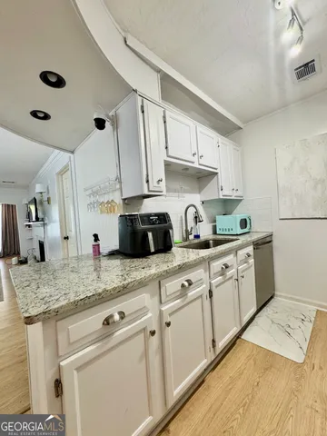 a kitchen with granite countertop a sink stainless steel appliances and cabinets