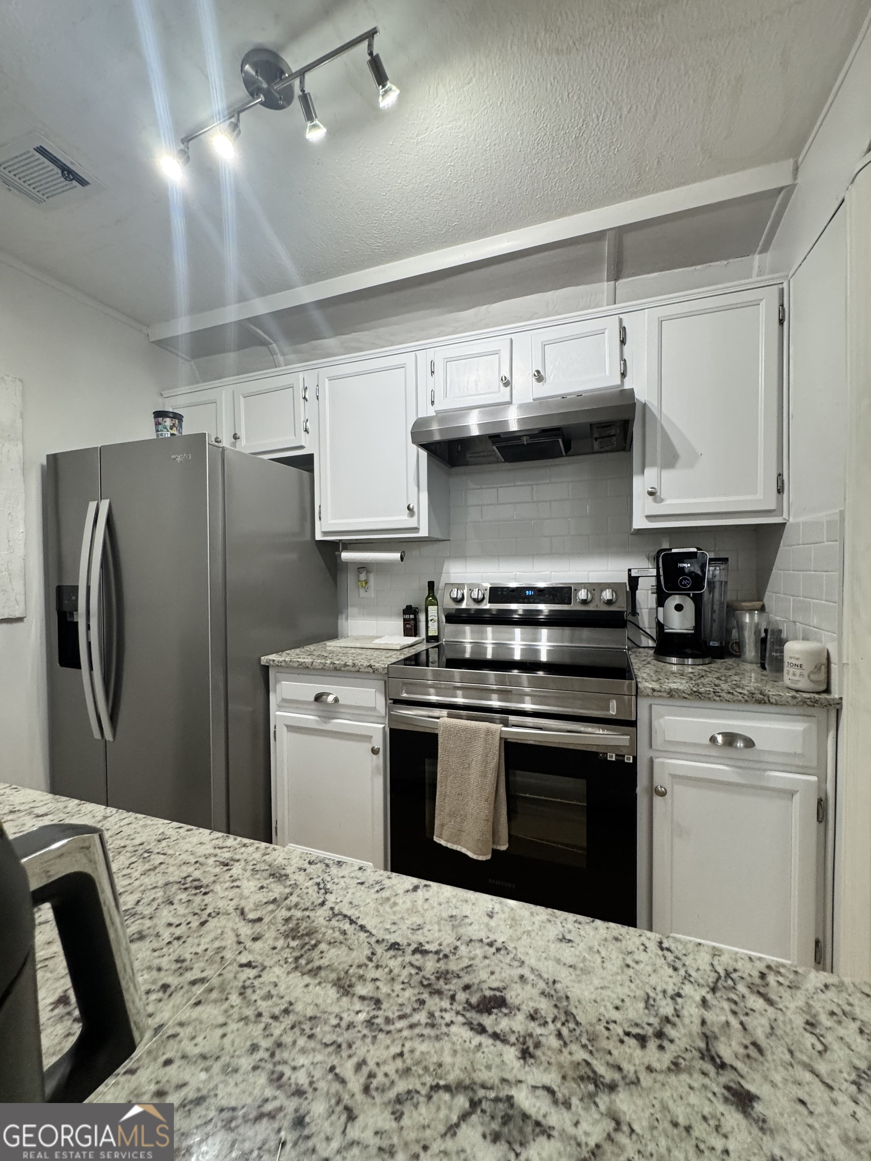 24311 Plantation Drive Northeast, Unit 311 Atlanta, GA 30324 - Photo 22 of 36 a kitchen with stainless steel appliances granite countertop a sink a stove a refrigerator and a sink