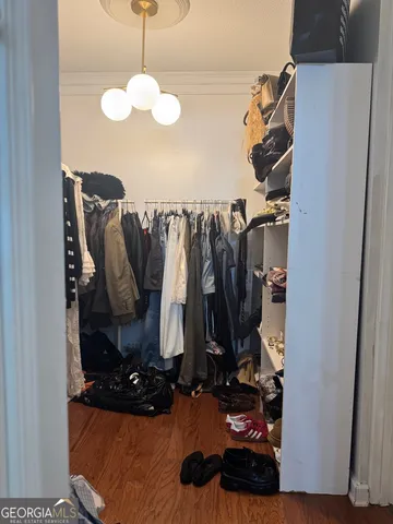 a view of walk in closet with clothes and shoes