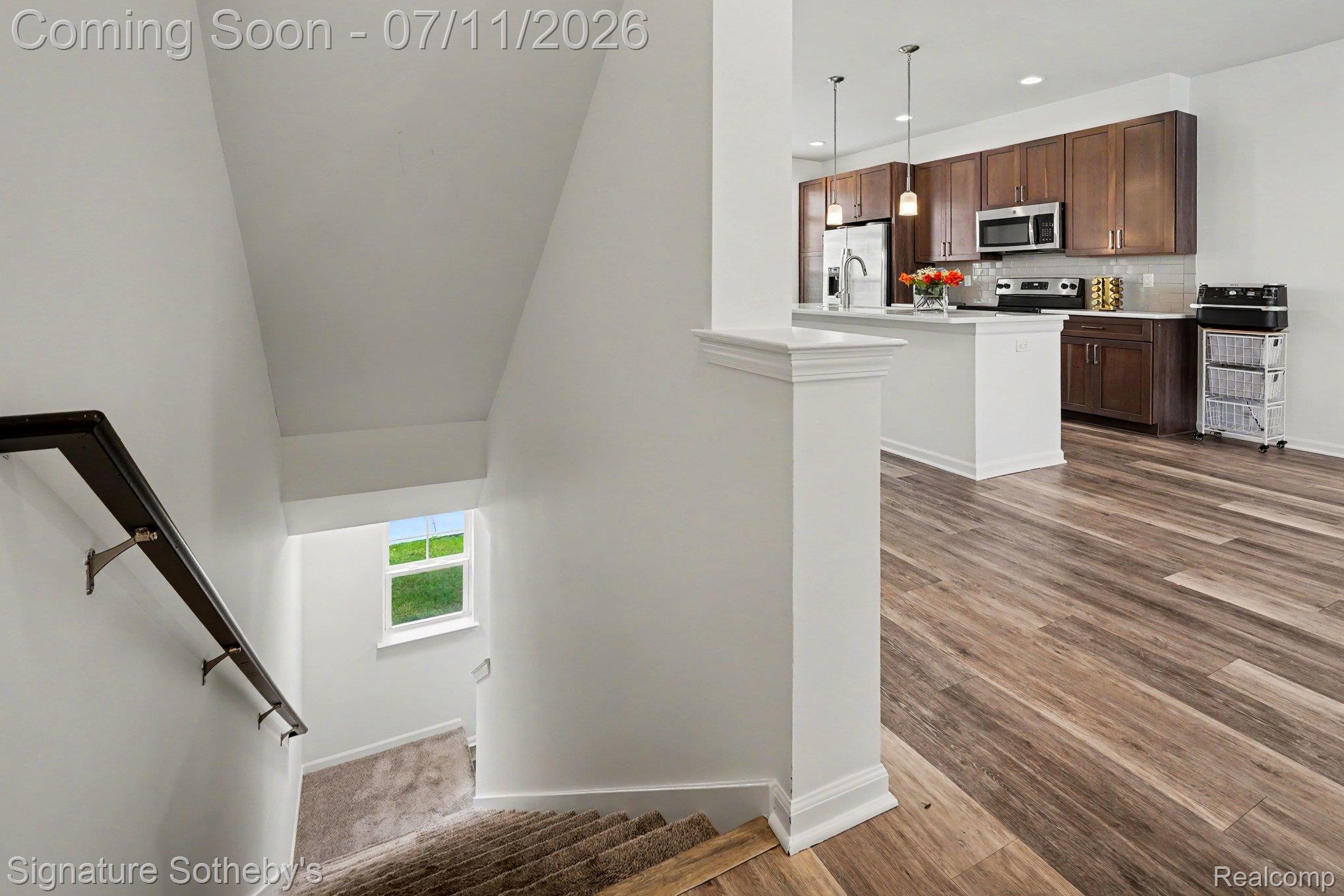 2500 Normandy Road, Unit 40 Royal Oak, MI 48073 - Photo 26 of 26 Open concept floor plan featuring a kitchen with dark wood-finish cabinetry, stainless steel appliances, and a central island with pendant lighting