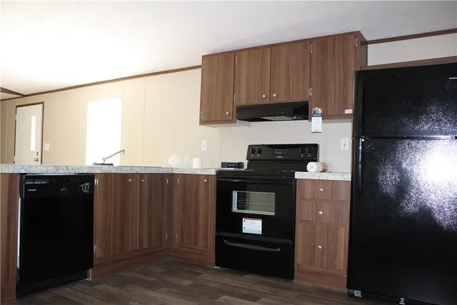 a kitchen with granite countertop wooden cabinets and black appliances