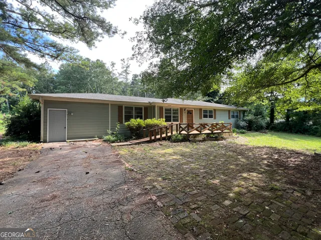 a view of a house with backyard and sitting area