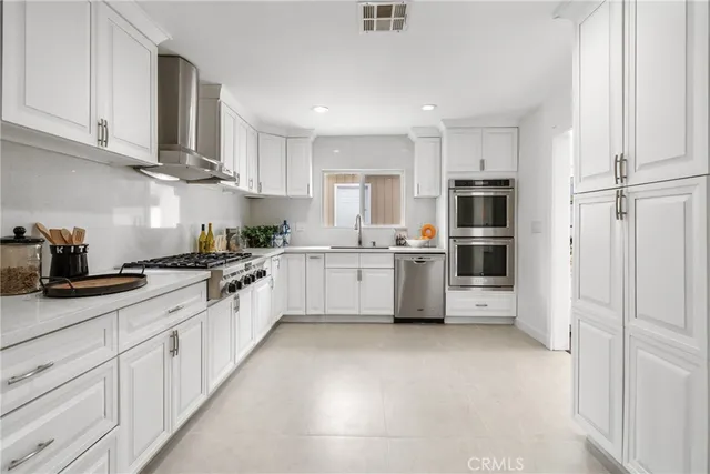 a large kitchen with cabinets and stainless steel appliances