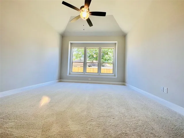 an empty room with a window and a fan