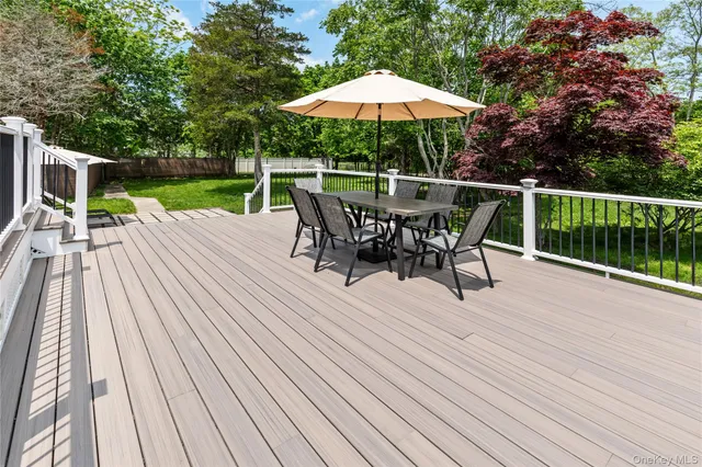 a view of a patio with table and chairs under an umbrella