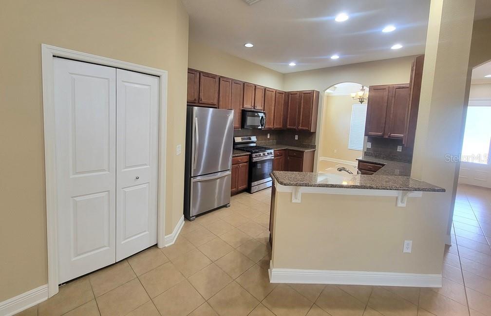 10418 Fenceline Road New Port Richey, FL 34655 - Photo 11 of 36 a kitchen with stainless steel appliances granite countertop a refrigerator a stove and a sink