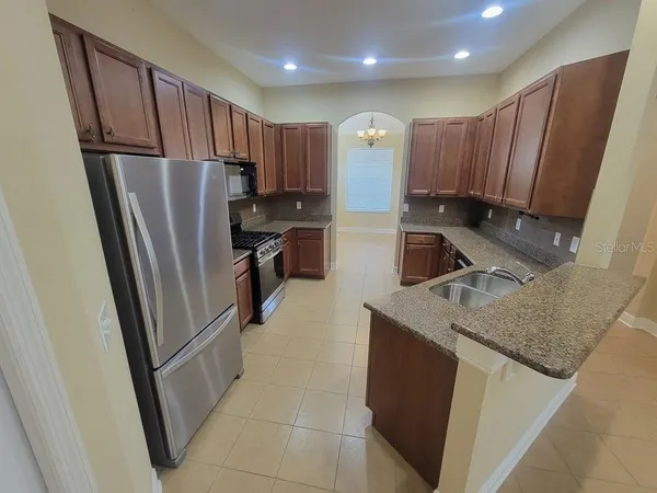 a kitchen with stainless steel appliances granite countertop a refrigerator stove a sink and dishwasher