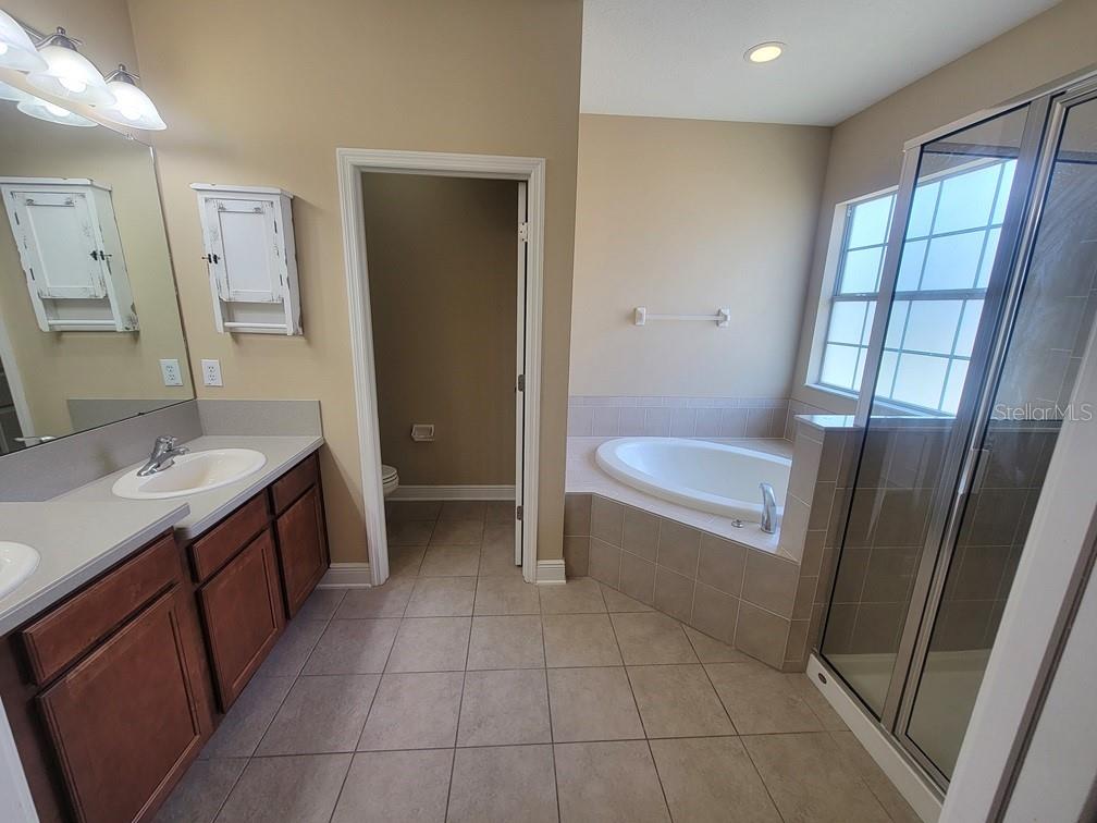 10418 Fenceline Road New Port Richey, FL 34655 - Photo 26 of 36 a bathroom with a sink a toilet and tub