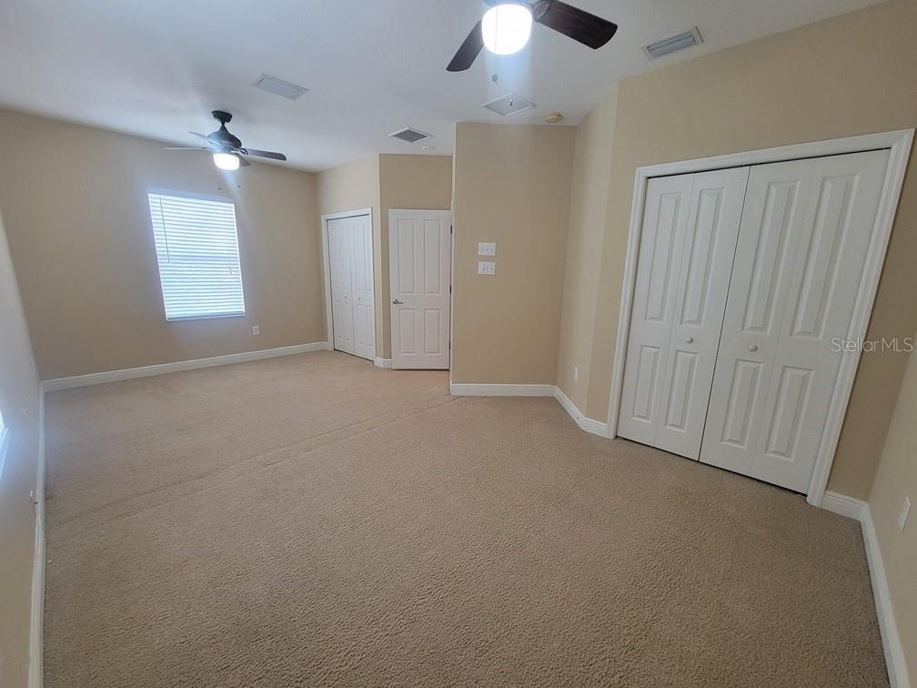 10418 Fenceline Road New Port Richey, FL 34655 - Photo 31 of 36 an empty room with chandelier fan and windows