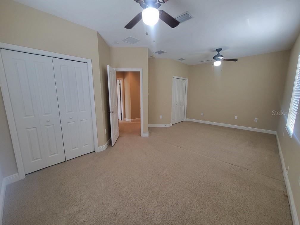 10418 Fenceline Road New Port Richey, FL 34655 - Photo 32 of 36 an empty room with chandelier fan and windows