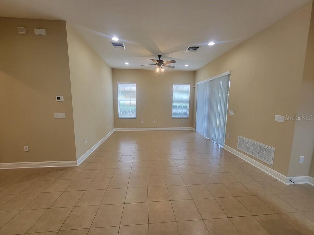 10418 Fenceline Road New Port Richey, FL 34655 - Photo 8 of 36 a view of an empty room with glass door and chandelier fan