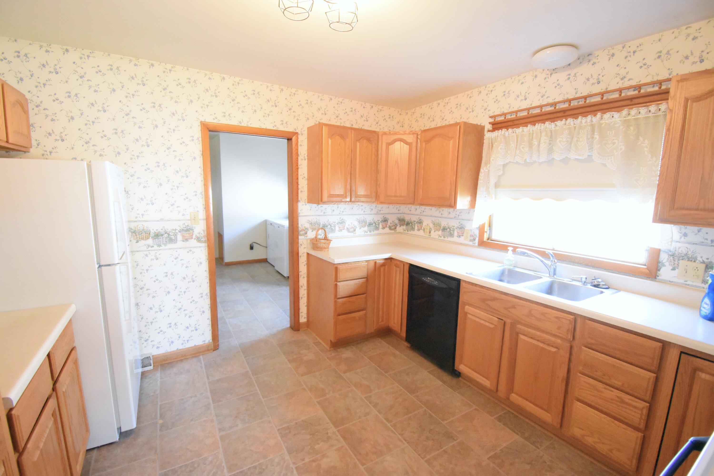 328 South Weston Street Rensselaer, IN 47978 - Photo 12 of 39 a large kitchen with a sink window and cabinets