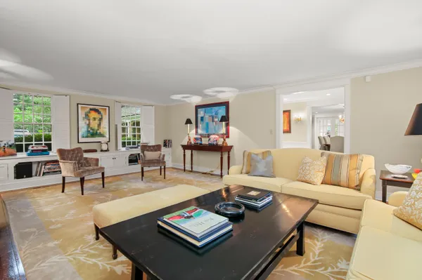 a living room with furniture large window and table