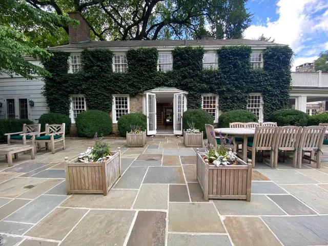 a view of a patio with couches table and chairs and potted plants
