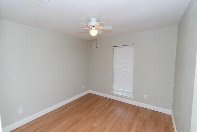 106 Mapleleaf Lane Coppell, TX 75019 - Photo 27 of 36 Room featuring light-colored walls, wood-finish flooring, white baseboards, a single window with blinds, and a ceiling fan with integrated lighting