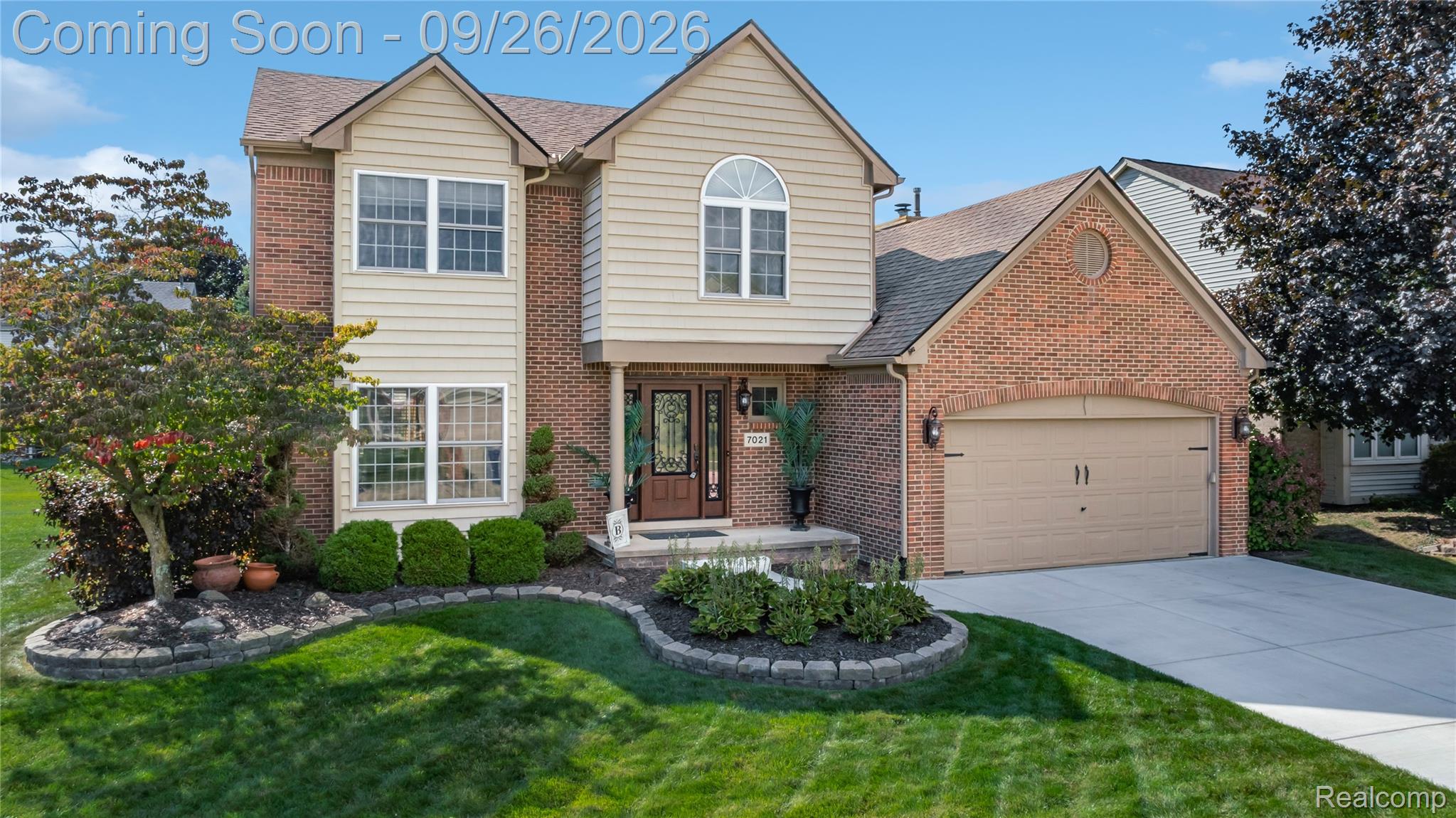7021 Fox Path Canton, MI 48187 - Photo 53 of 59 Brick and siding exterior with a two-car garage, front entry with transom window, and mature landscaping