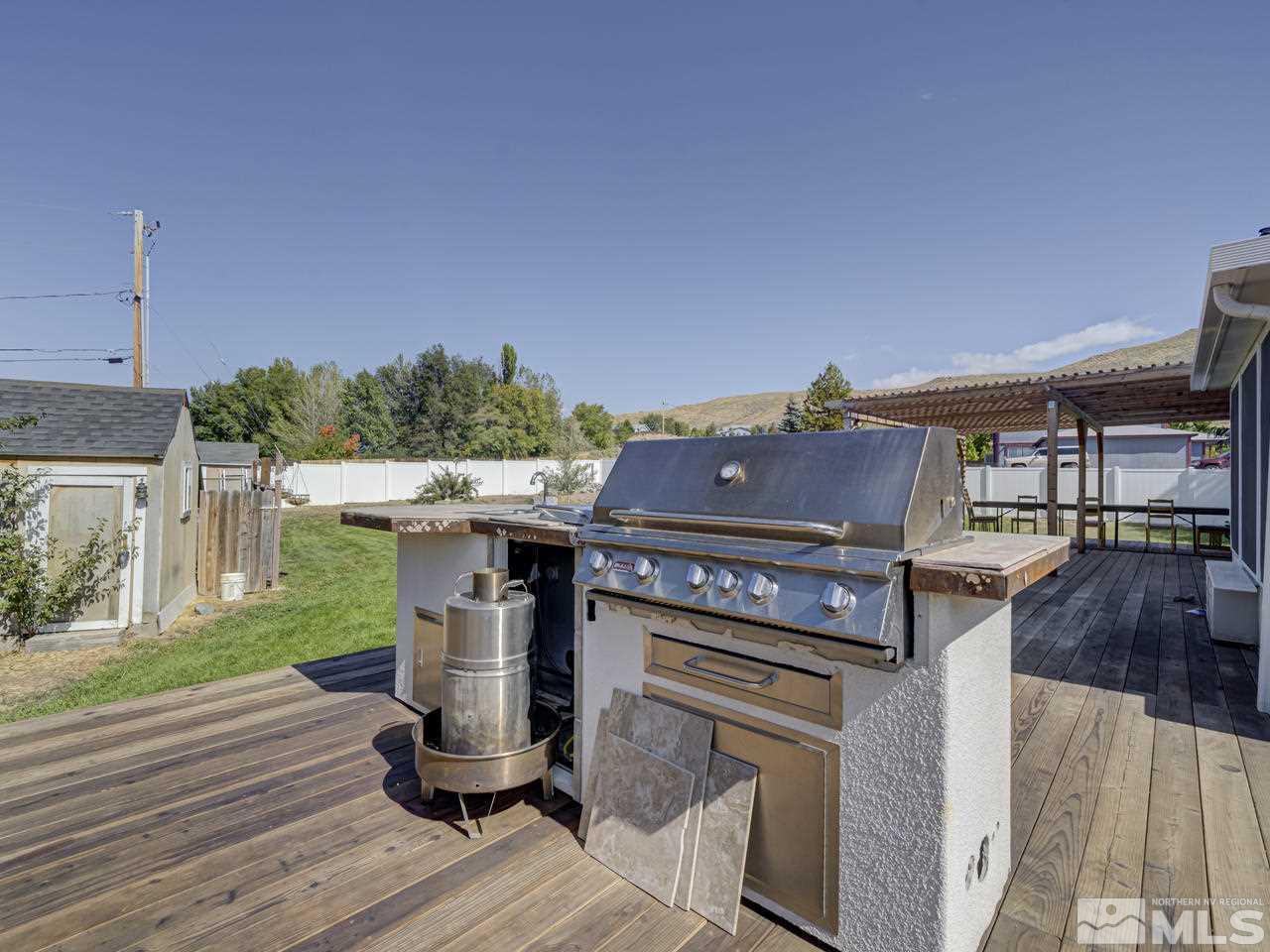 17175 Waxwing Street Reno, NV 89508 - Photo 8 of 25 a view of a patio with table and chairs a barbeque with wooden floor and fence