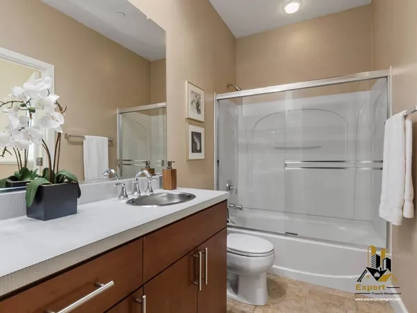 a bathroom with a sink a toilet and shower