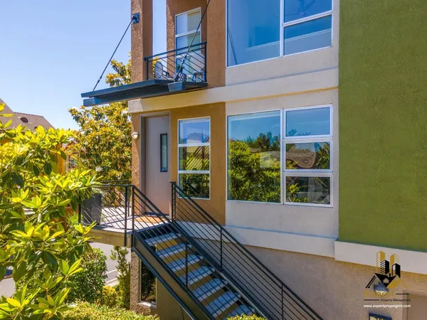 a view of a balcony with table and chairs and potted plants