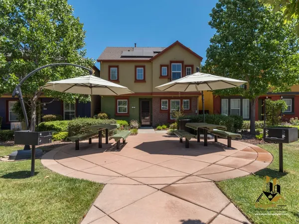 a view of a patio with a table and chairs under an umbrella
