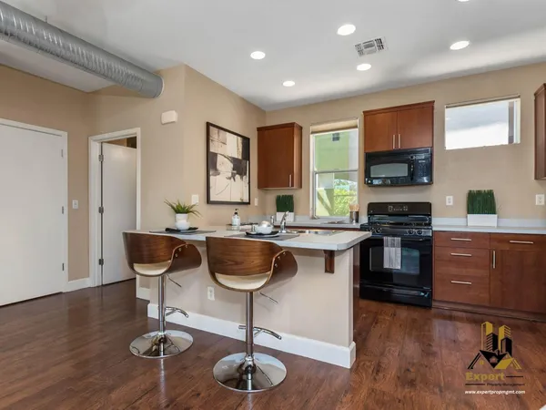 a kitchen with granite countertop a stove and chairs