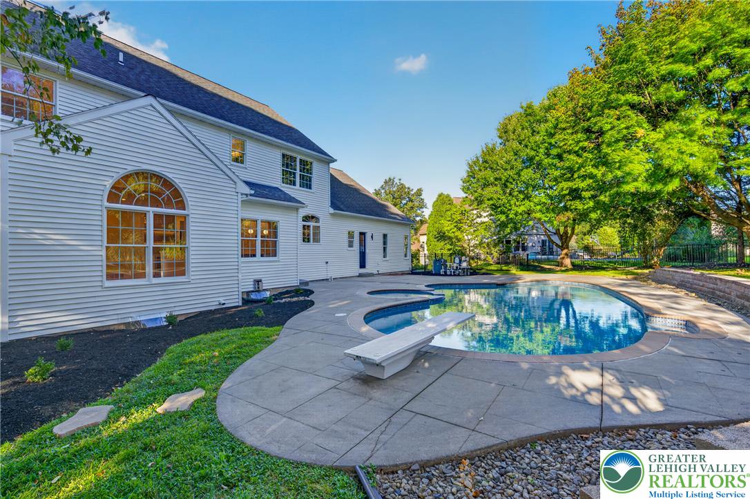 3130 Muirfield Road Center Valley, PA 18034 - Photo 59 of 63 An inviting pool and concrete patio sit alongside this vinyl-sided home with mature trees.