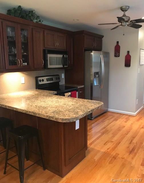 3510 Mack Ballard Road, Unit 13 Maiden, NC 28650 - Photo 5 of 24 a kitchen with granite countertop a stove refrigerator and microwave