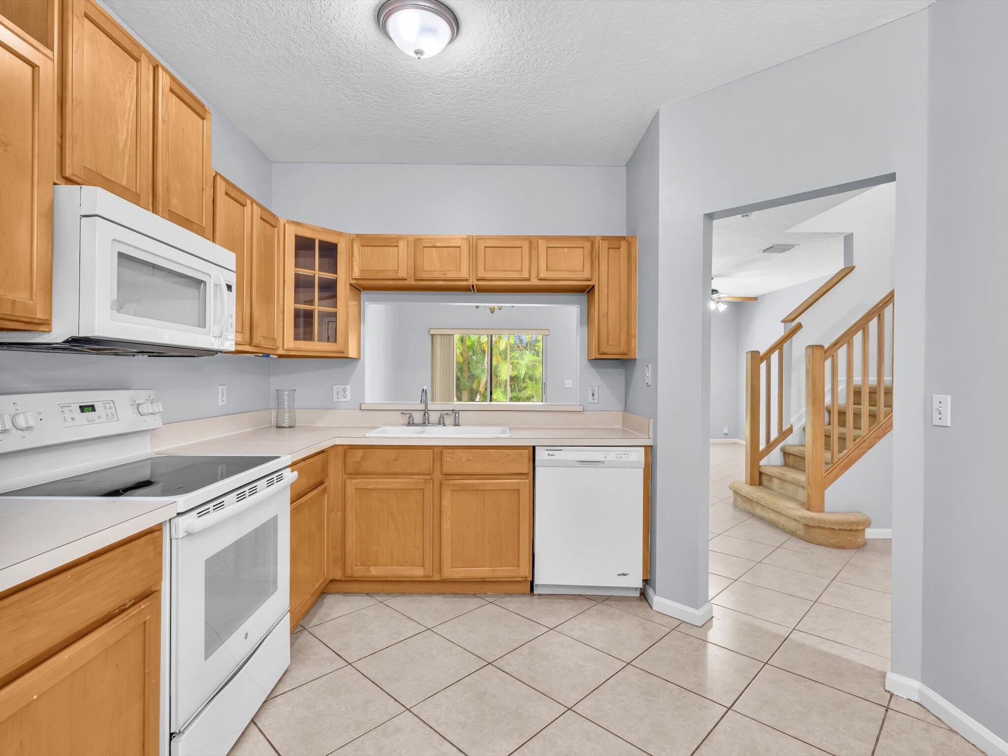 21018 Vía Eden, Unit 21018 Boca Raton, FL 33433 - Photo 2 of 63 a kitchen with a stove a sink and a microwave