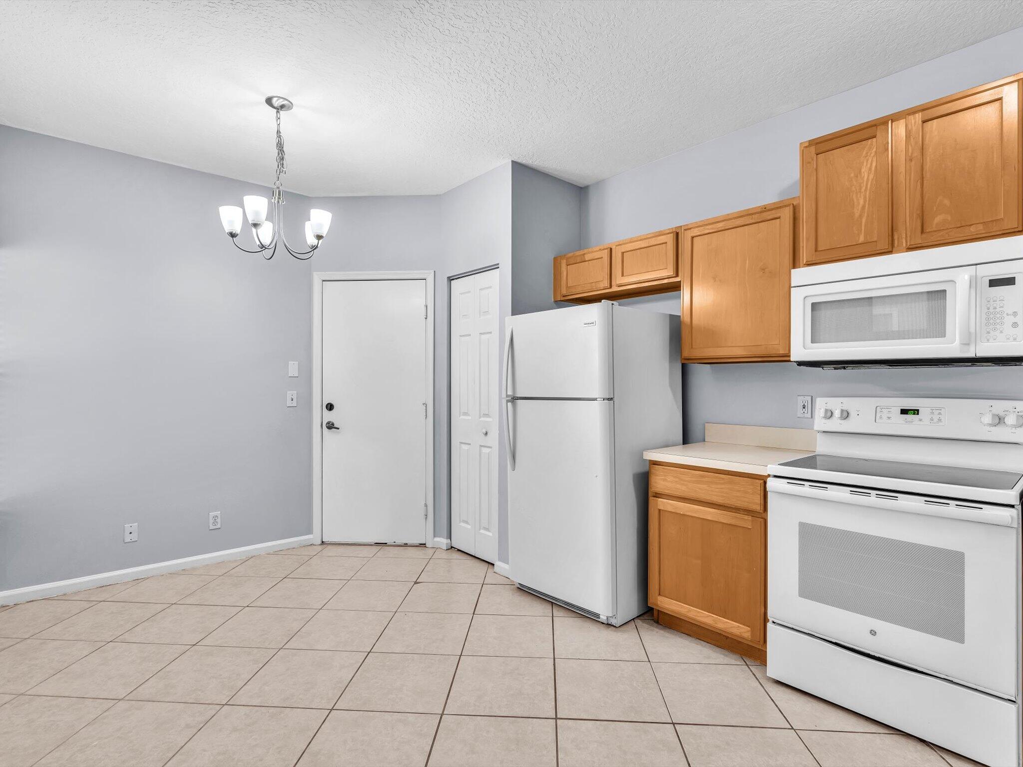 21018 Vía Eden, Unit 21018 Boca Raton, FL 33433 - Photo 5 of 63 a kitchen with a stove a sink and a refrigerator