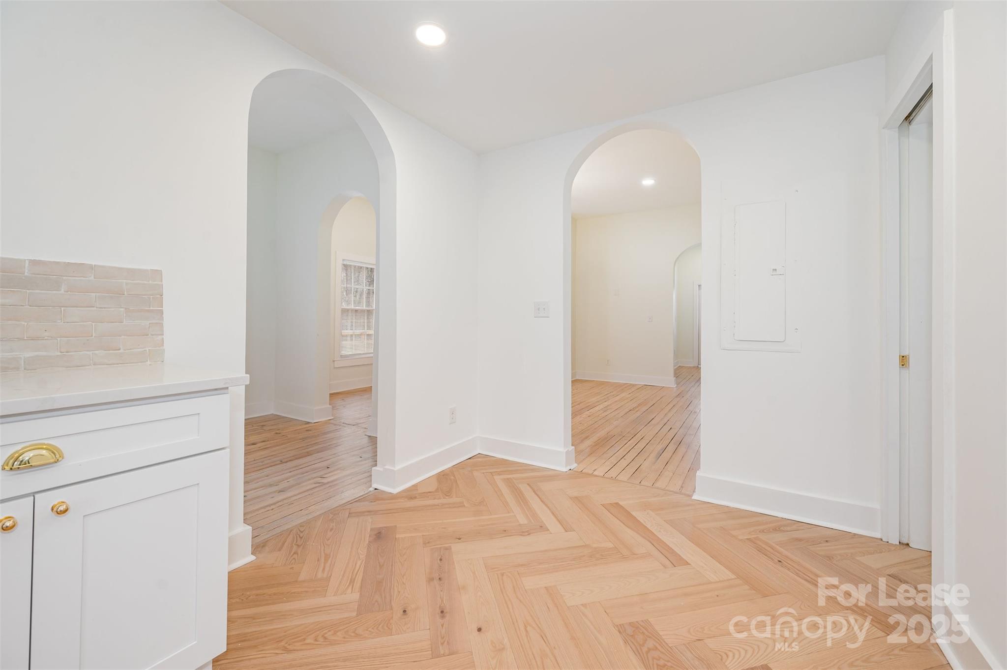 3612 East Brief Road Monroe, NC 28110 - Photo 12 of 22 an empty room with wooden floor and cabinet