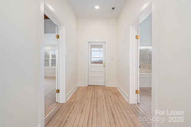 a view of a hallway with wooden floor and entryway
